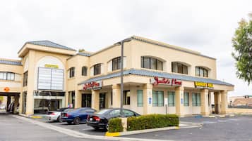 Un edificio con un letrero que dice 'Center', 'Jungle Pizza' y 'Salón de Banquetes', y un estacionamiento con coches.