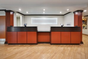 A reception desk area with two counters, a large window, and a sign for Marriott Bonvoy.