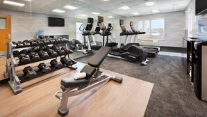 A gym with exercise equipment, a bench, and a water dispenser. - Fairfield Inn & Suites by Marriott Hinesville Fort Stewart (Hinesville)