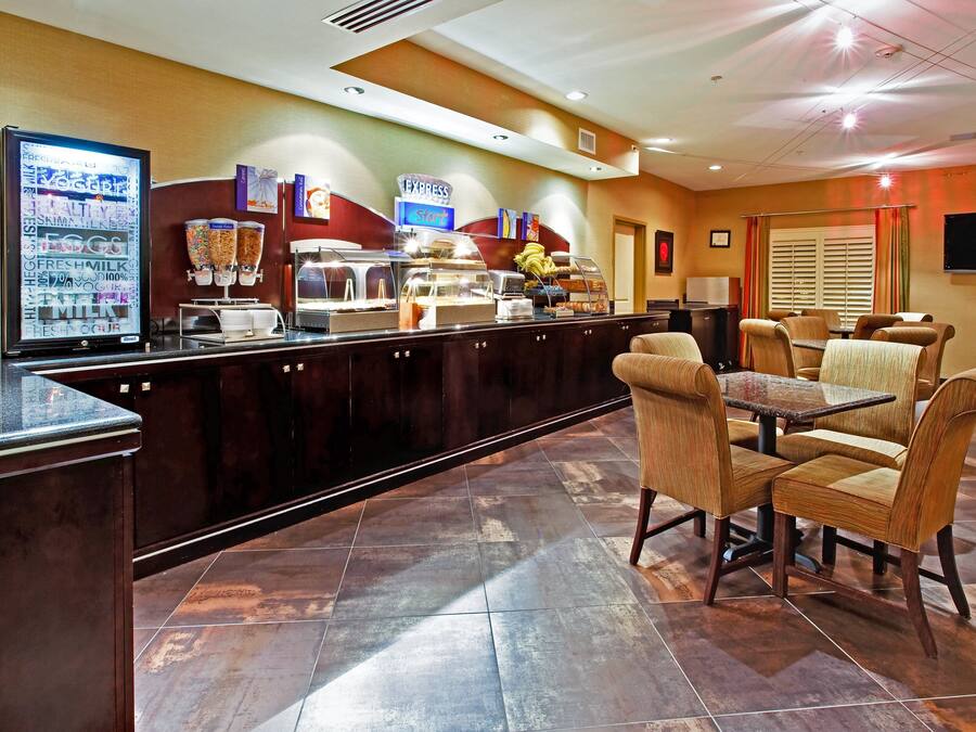 Un área de desayuno de hotel con mostrador, asientos y televisor.