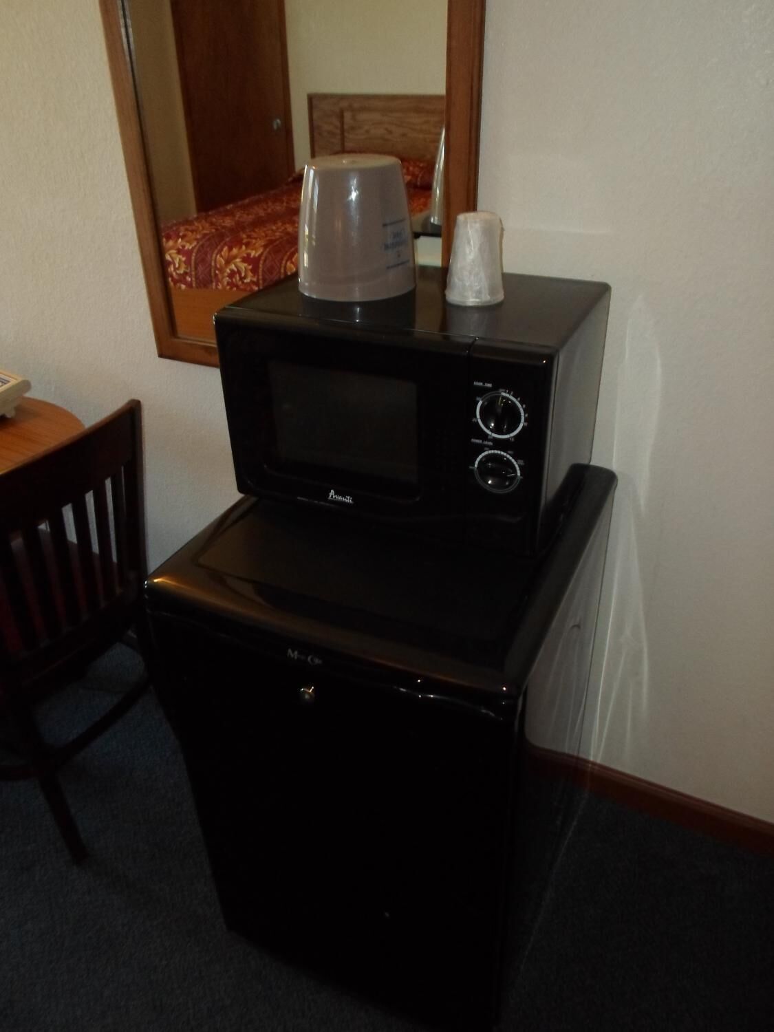 A compact kitchenette with a microwave and a small refrigerator.