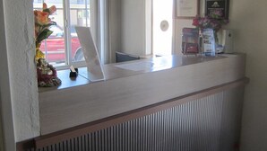 A reception desk with a view of the street outside. - Pacific Best Inn (Seaside)