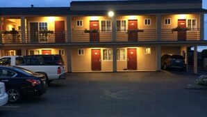 A two-story motel with a parking lot. - Pacific Best Inn (Seaside)
