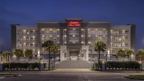 Een groot, meerlaags hotel met een opvallend bord waarop 