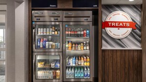 Een rij gekoelde drankdispensers met een bordje 'Treats' erboven.