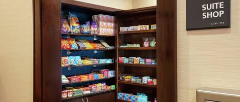 Una tienda de suites con estantes llenos de aperitivos y bebidas.