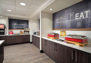 A modern kitchen area with dark wooden cabinets, a white countertop, and a chalkboard wall with the word "EAT" and related drawings. - Hampton Inn & Suites Las Vegas-Red Rock/Summerlin (Las Vegas)