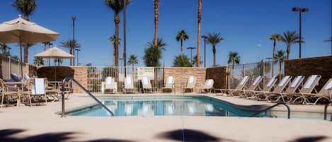 Una piscina al aire libre, tumbonas