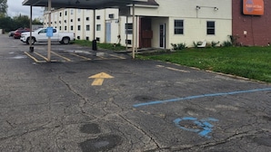 A two-story building with a covered parking area and a sign for the Airport Inn.