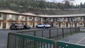 Motel amb diverses plantes i un aparcament.