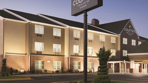 A Country Inn & Suites building with a signboard, brick facade, and multiple windows. - Country Inn & Suites by Radisson, Washington, D.C. East - Capitol Heights, MD (Capitol Heights)