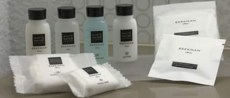 A collection of skincare products from the Beekman brand, including lotions, a facial bar, and a makeup remover wipe.