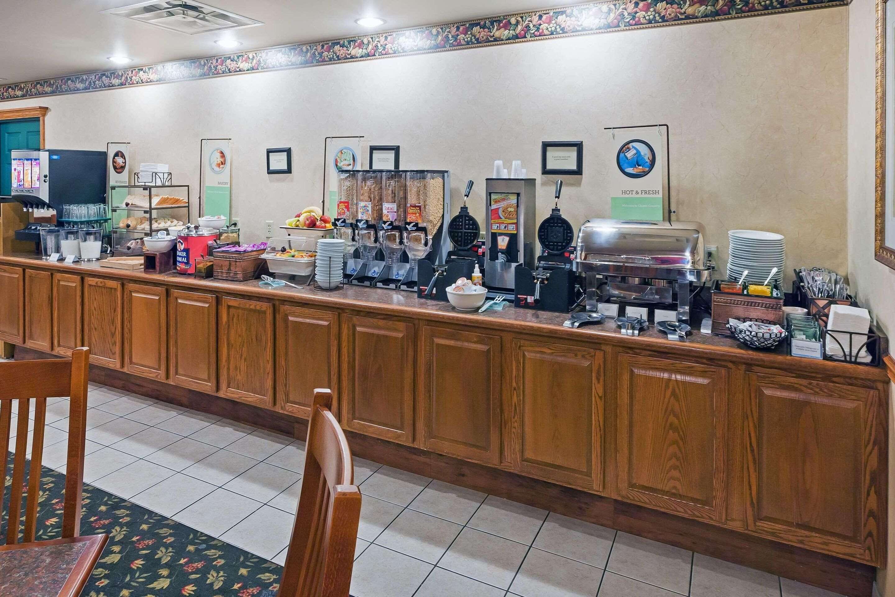 A breakfast bar with coffee machines, a fruit display, and a salad bar.