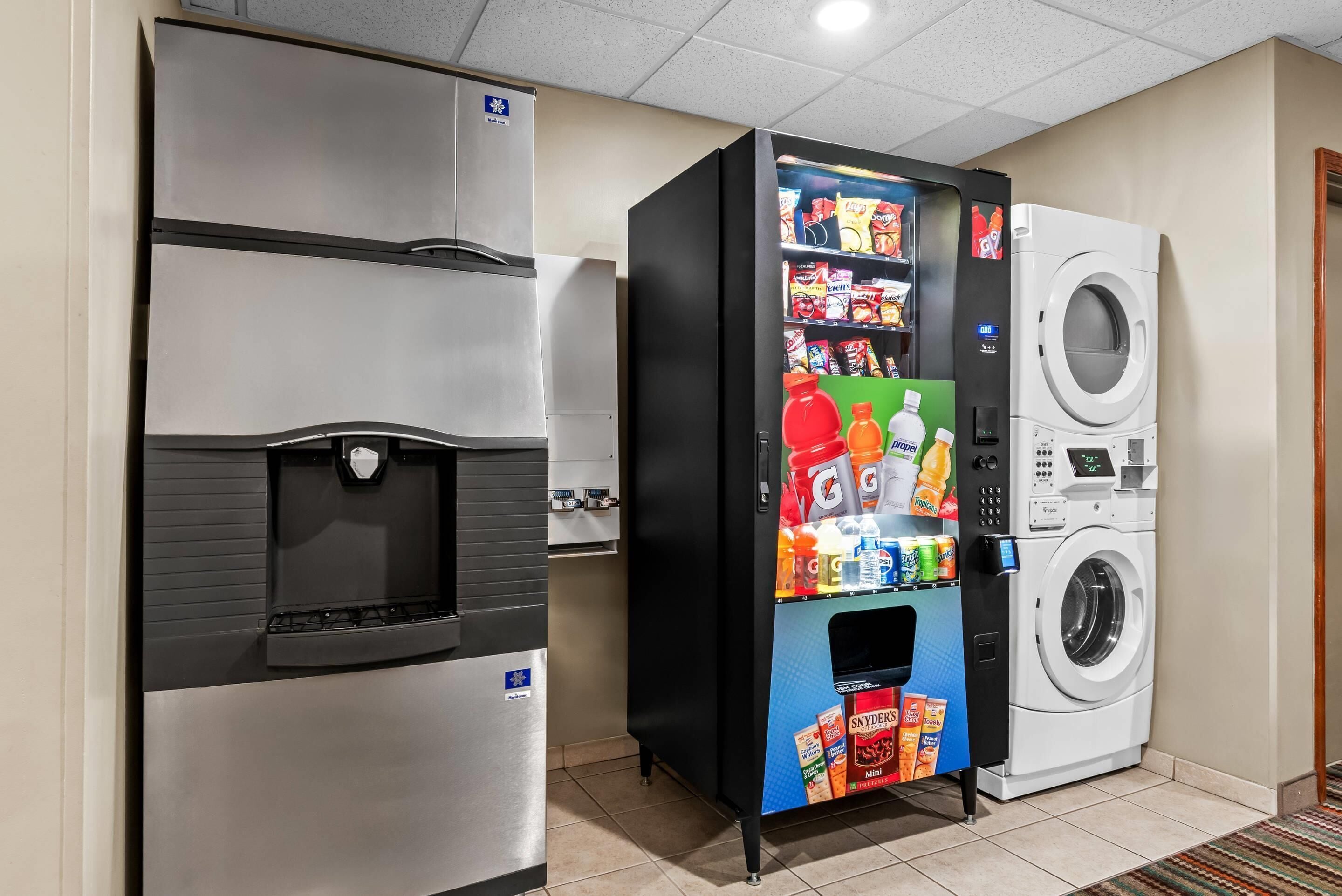 Un distributeur automatique de collations et de boissons, un distributeur d’eau et un lave-linge.