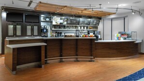 A modern kitchen with wooden cabinets, a stainless steel countertop, and a built-in coffee machine. - Courtyard by Marriott Pittsburgh Greensburg (Greensburg)