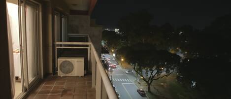 A balcony with a view of a street at night.