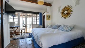 Un dormitorio con una cama grande, un escritorio y una silla cerca de una ventana.