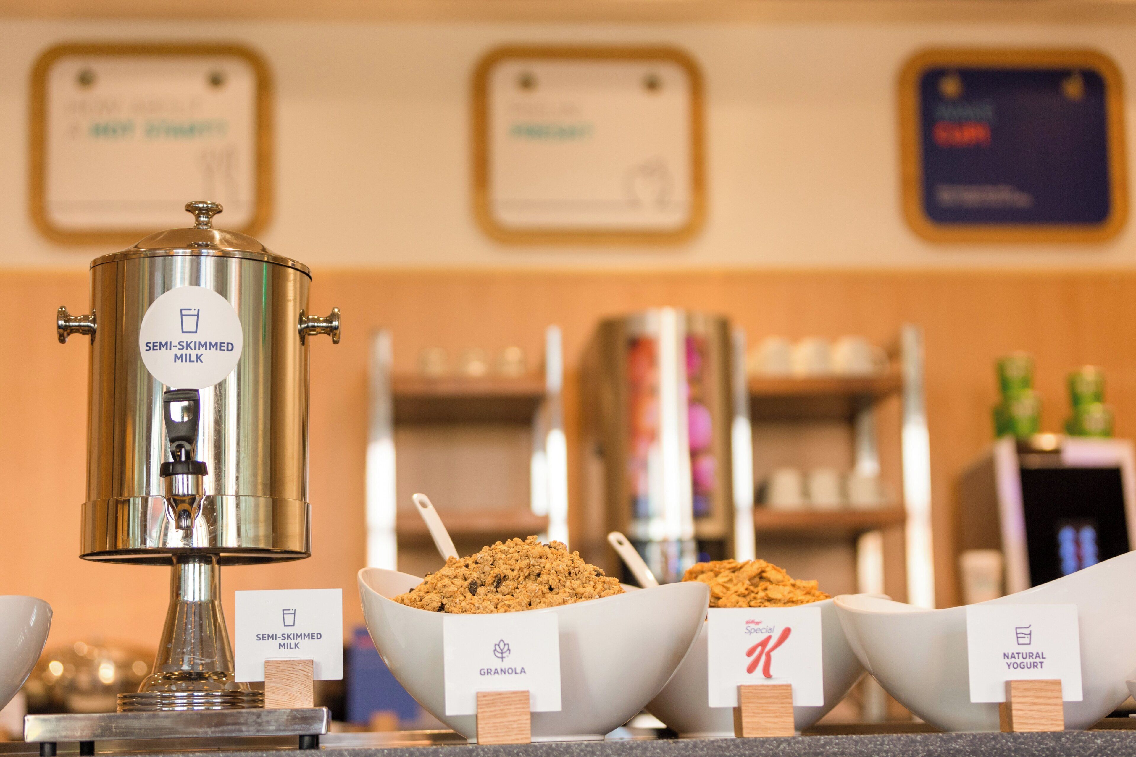 Ein Buffet mit einer teilentrahmten Milchmaschine, Schalen mit Granola und einer Ecke für Naturjoghurt.