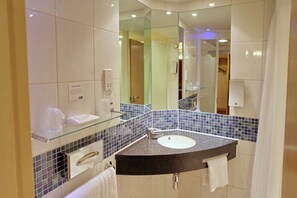 Une salle de bain moderne avec une étagère en verre, un lavabo et un miroir.