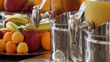 A juicer with fruits and a glass of juice.