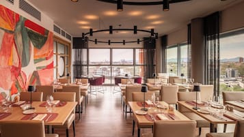 A restaurant with tables set for dining, large windows offering a city view, and a modern interior design.