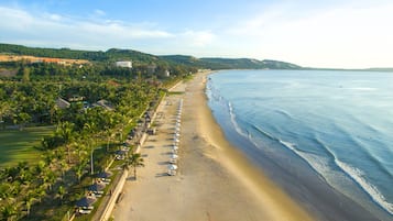 On the beach, white sand, sun loungers, beach umbrellas