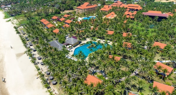 An aerial view of a resort with multiple buildings, a large swimming pool, and a beach. - Pandanus Resort (Mui Ne)