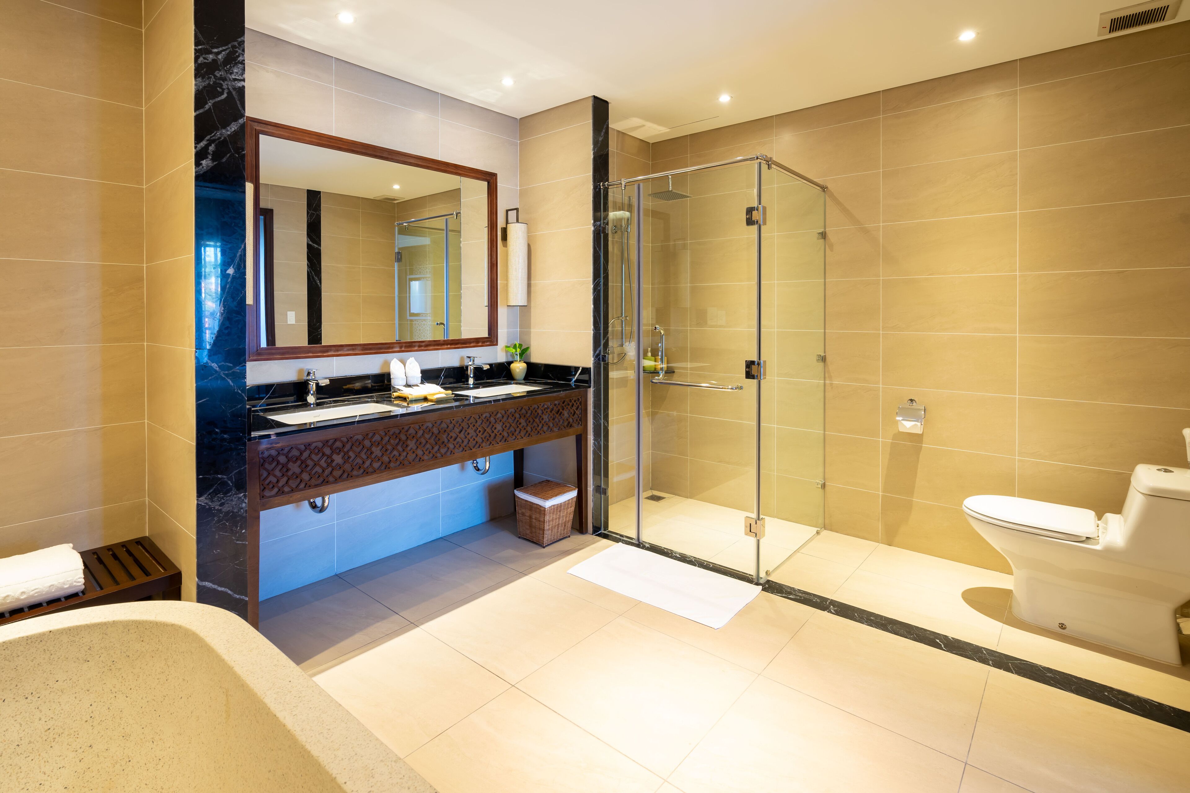 A modern bathroom with a glass-enclosed shower, a large mirror, and a bathtub.