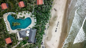 An aerial view of a resort with a swimming pool, beach, and palm trees. - Pandanus Resort (Mui Ne)