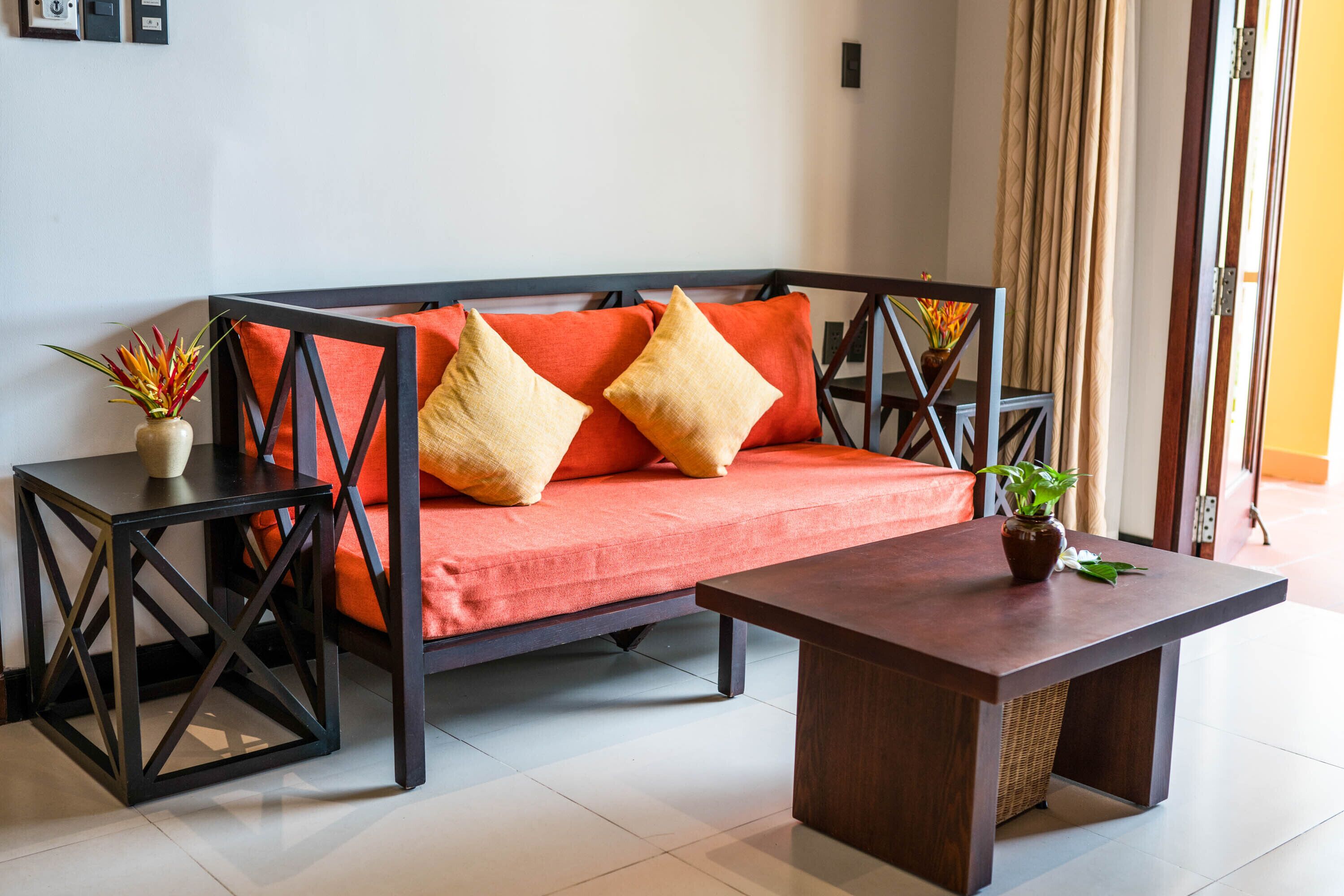 A modern living room with a sofa, two side tables, and a coffee table.