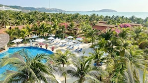 A resort with a swimming pool, lounge chairs, and palm trees. - Pandanus Resort (Mui Ne)