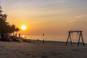 On the beach, white sand, sun loungers, beach umbrellas
