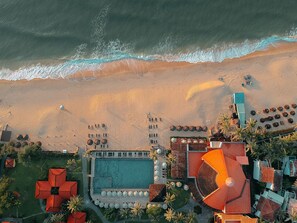 Trên bãi biển, cát trắng, ghế dài tắm nắng, dù trên bãi biển
