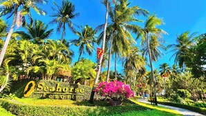 Señal para el Resort Seahorse, con jardines tropicales y palmeras.
