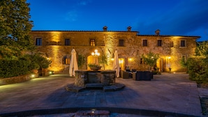 Un edificio de piedra con múltiples ventanales y un patio.