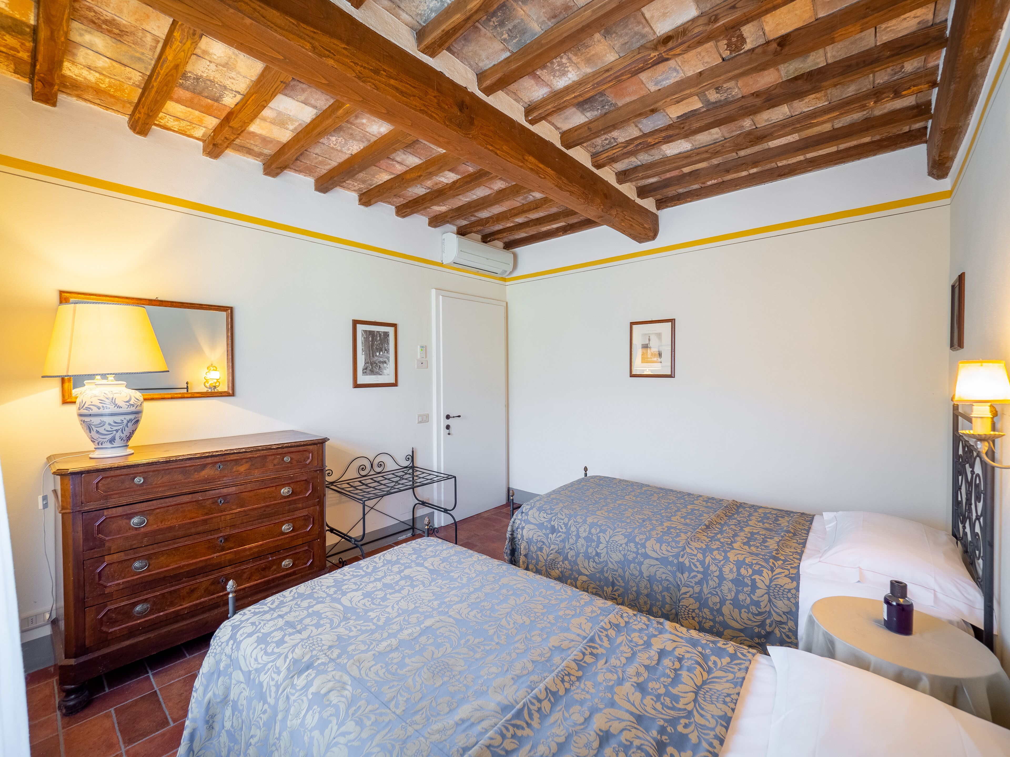 Un dormitorio con dos camas, un aparador, una lámpara y un espejo.