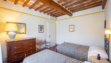 Un dormitorio con dos camas, un aparador, una lámpara y un espejo.