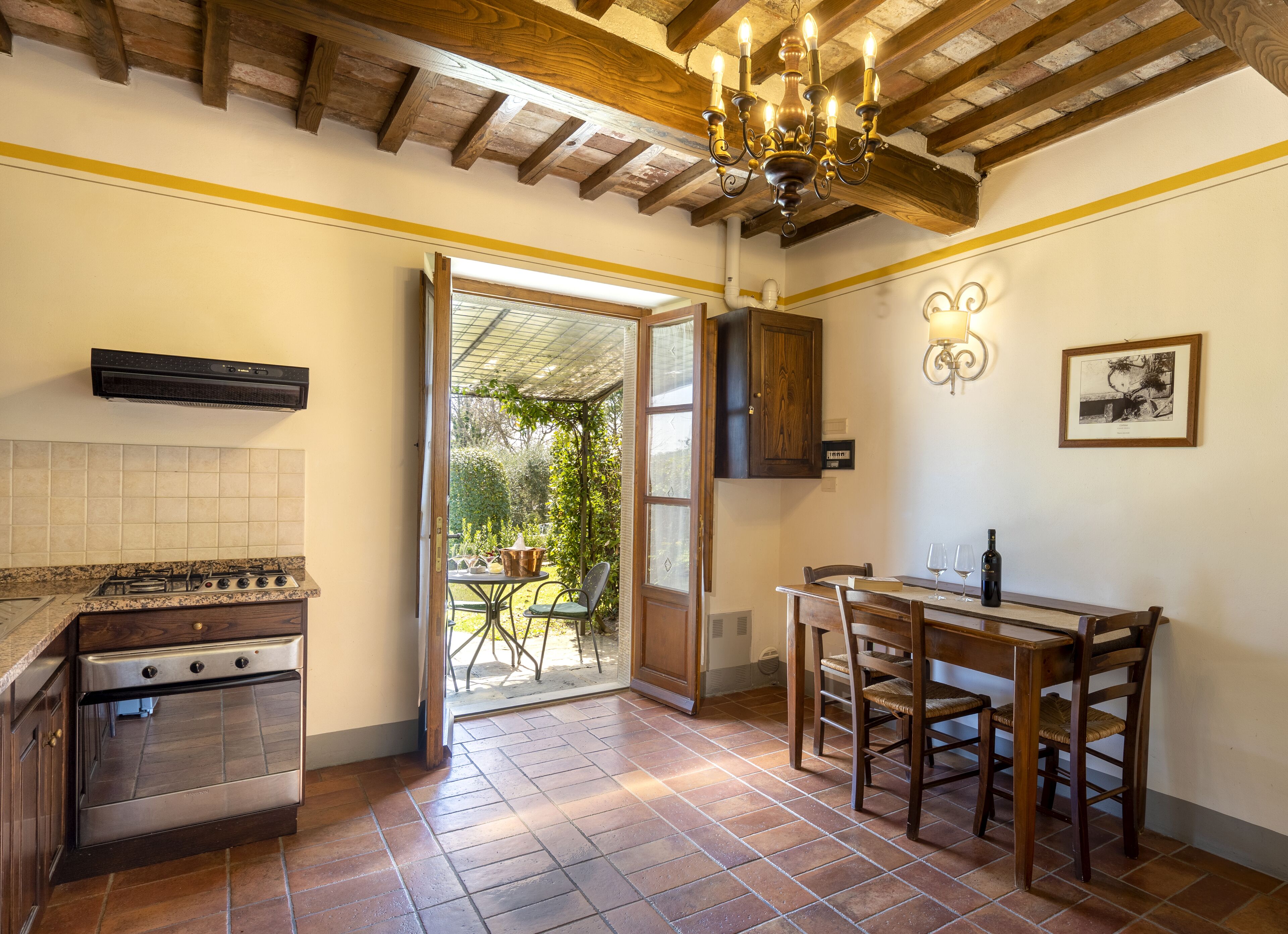 A kitchen with a gas stove, oven, and a dining area with a table and chairs.