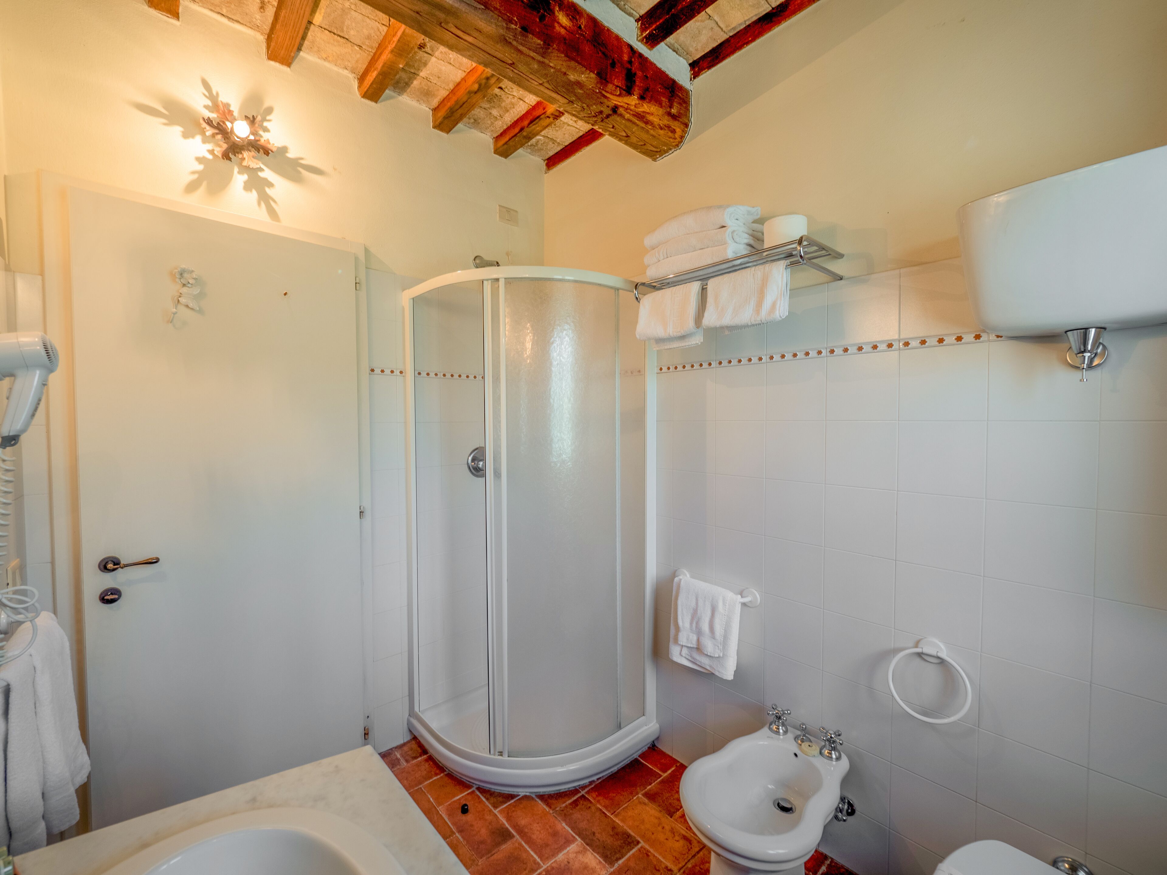 Une salle de bain équipée d’une douche, d’un bidet, de toilettes et d’un porte-serviettes.
