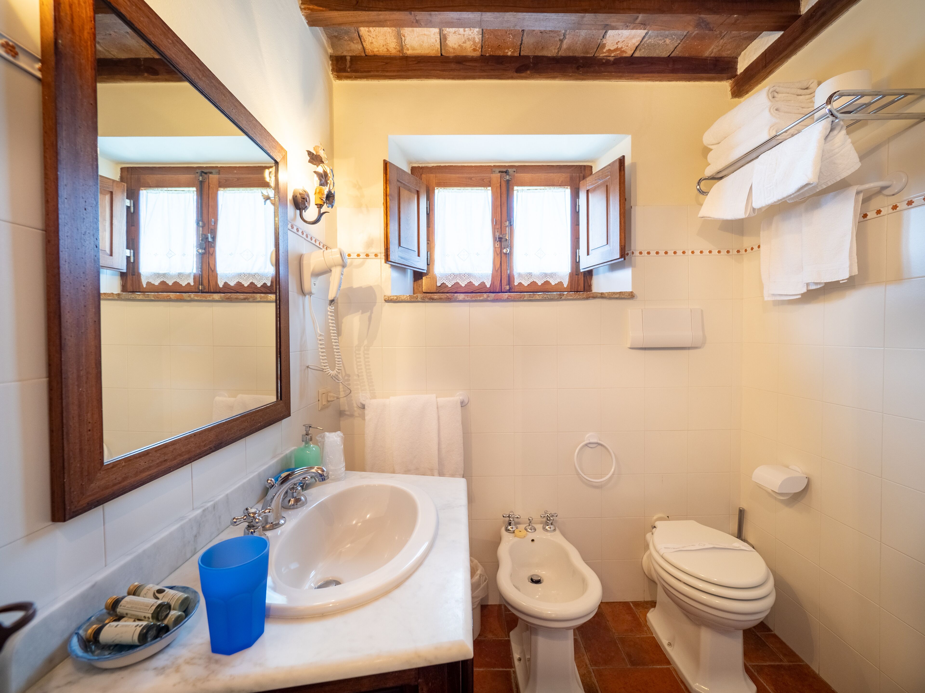 Un baño con lavamanos, bidé, inodoro y espejo.