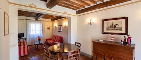 Un comedor con mesa y sillas de madera, un sofá y una chimenea.