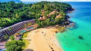 Ein Resort mit Strand, Pool und üppiger Bepflanzung.