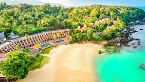 Ein Resort mit Pool, Strand und üppiger Bepflanzung.