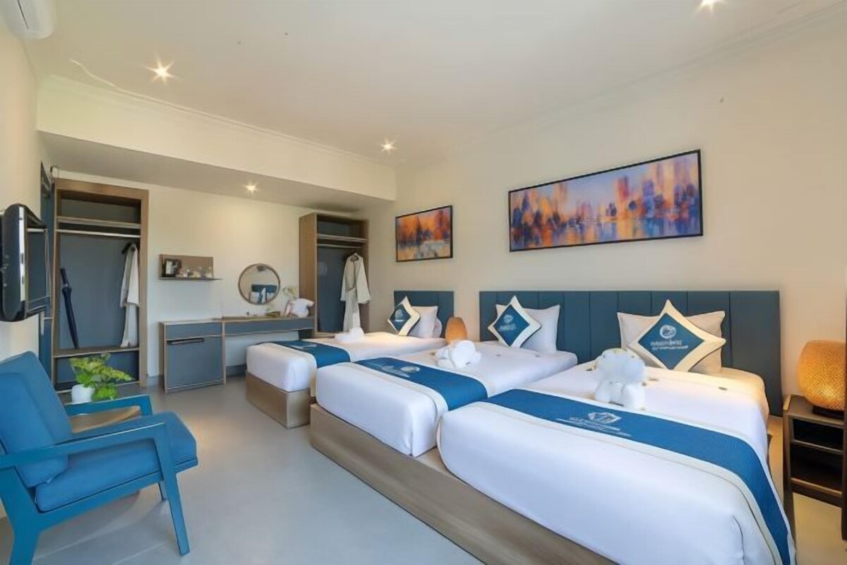Een hotelkamer met twee bedden, een bureau, een stoel en kunstwerken aan de muur.