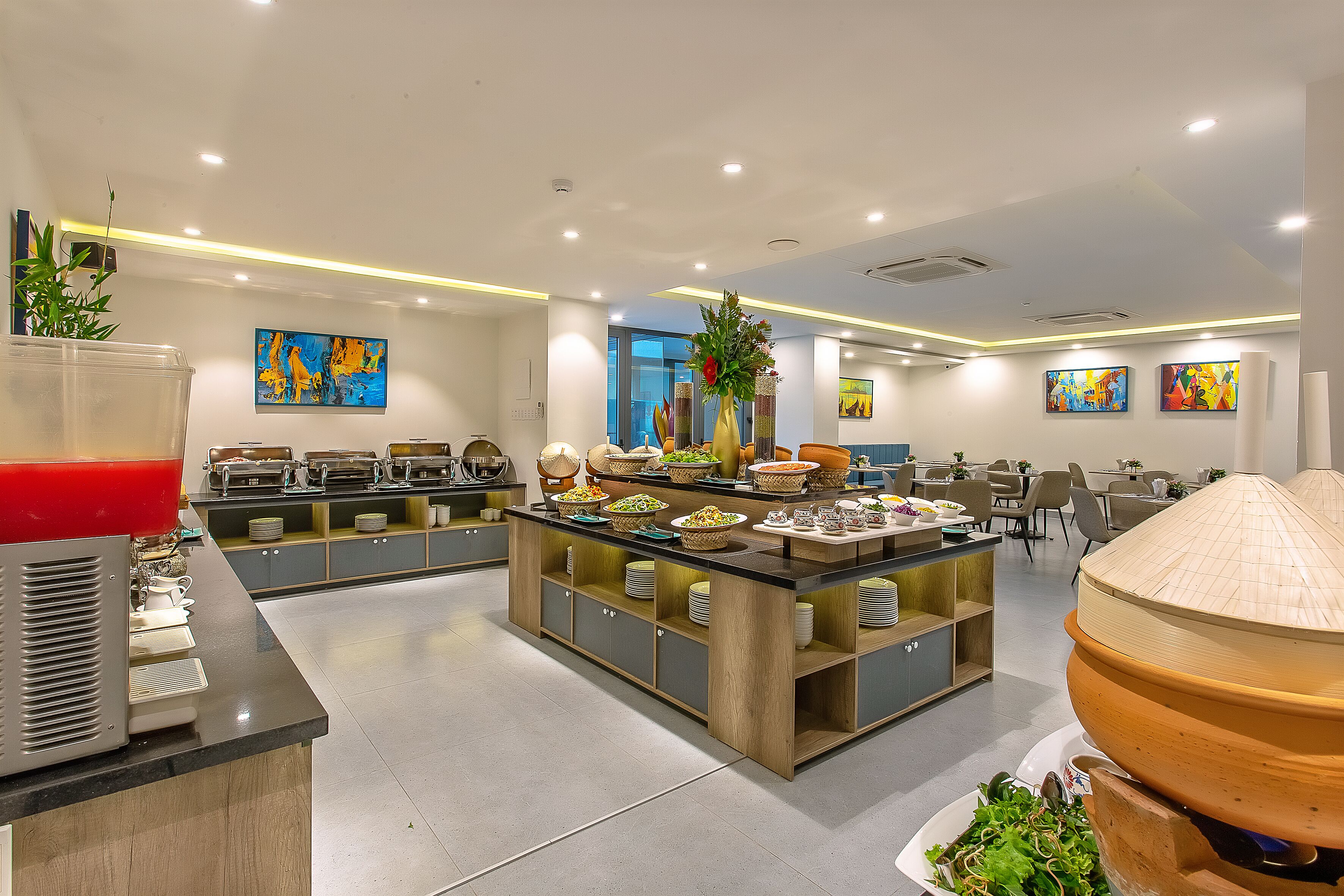 Un área de desayuno moderno en un hotel, con un bufé que ofrece una variedad de alimentos y una estación de café.