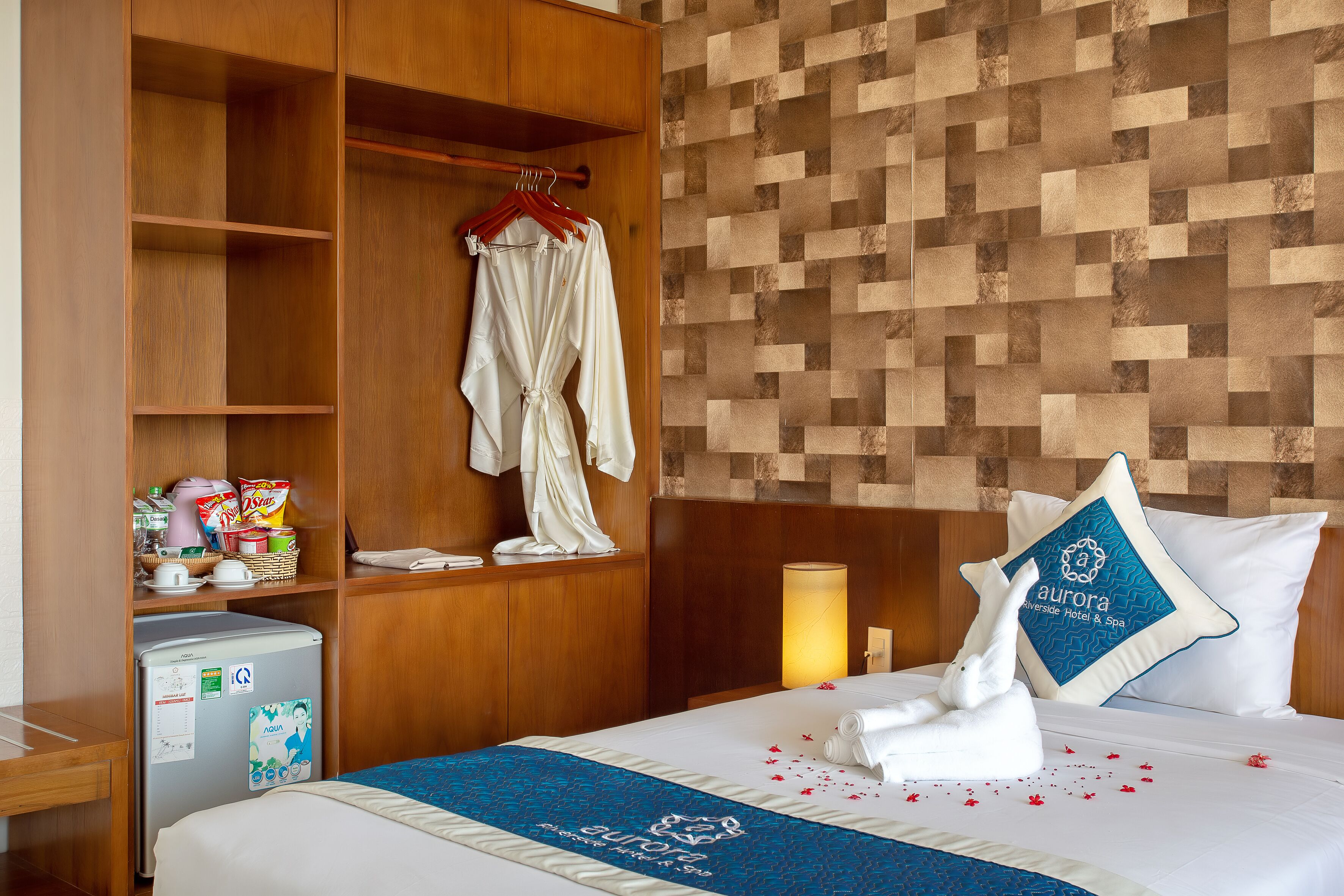Ein Hotelzimmer mit Bett, Kleiderschrank, Schreibtisch und Kühlschrank.