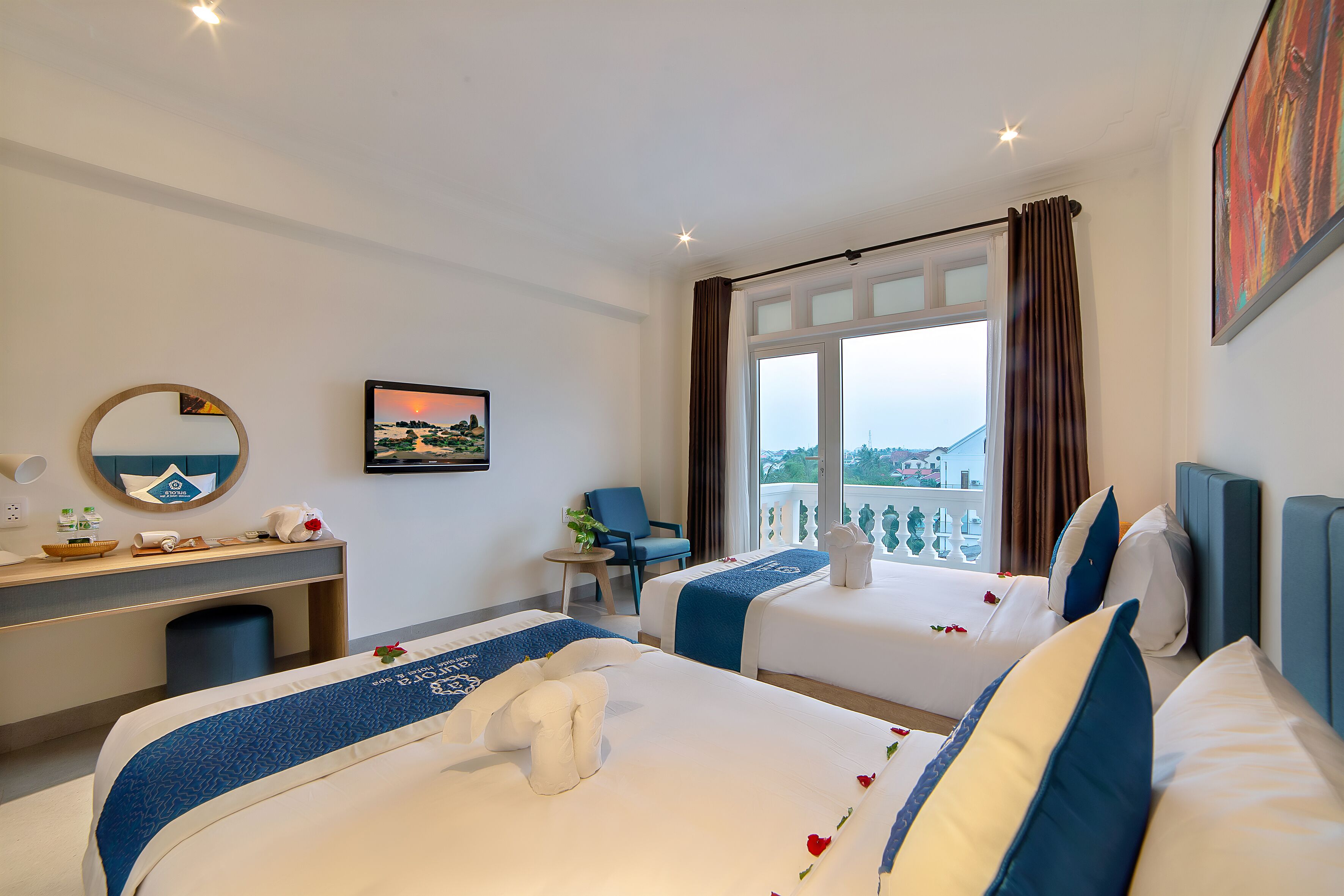 Une chambre d’hôtel avec deux lits, un bureau, une chaise et une fenêtre donnant sur un paysage agréable.