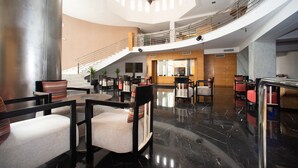 A spacious lobby with a high ceiling, a central staircase, and multiple seating areas. - Timoulay Hotel & Spa Agadir (Agadir)