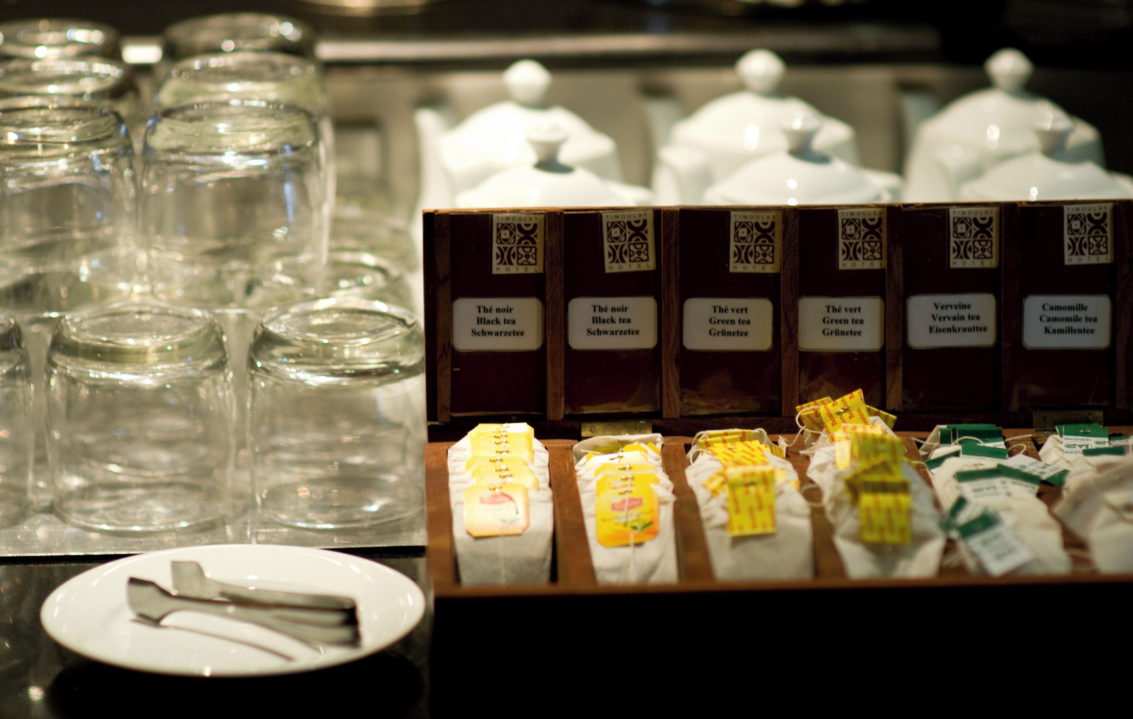 A tea display with various tea bags and empty glass jars.