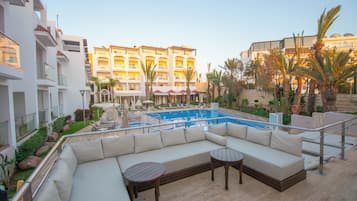 Een buitenzwembad, parasols bij het zwembad en ligstoelen